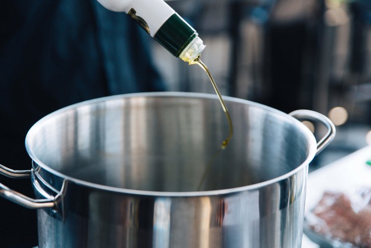 olive oil being poured in a pot