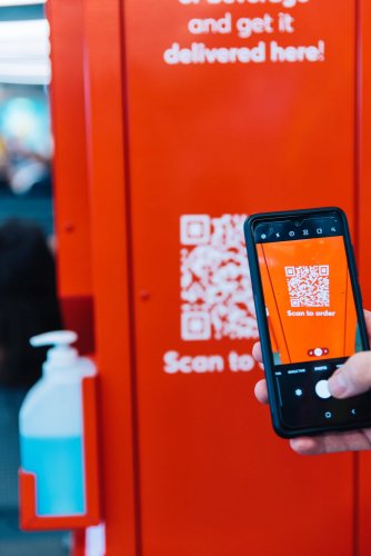 someone scanning a QR code from a red column.