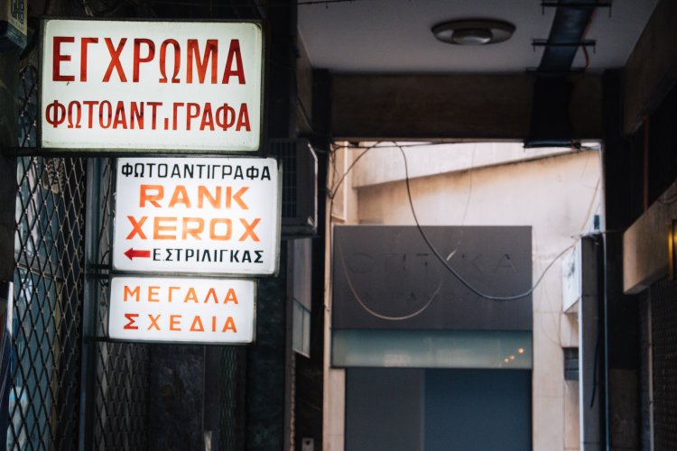 three signs in an arcade regarding a phtocopy store.