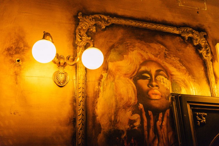 a picture of a drag queen on the wall of a bar.