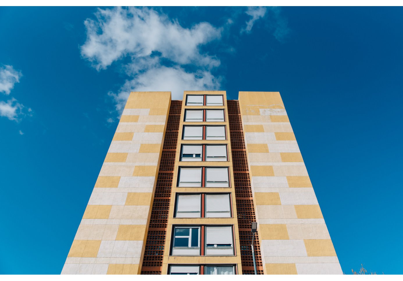 a tall building with orthogonal composition, blue sky above.