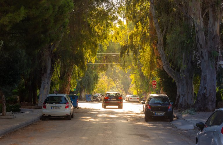 Car driving on leafy street in Glyfada, Athens Riviera