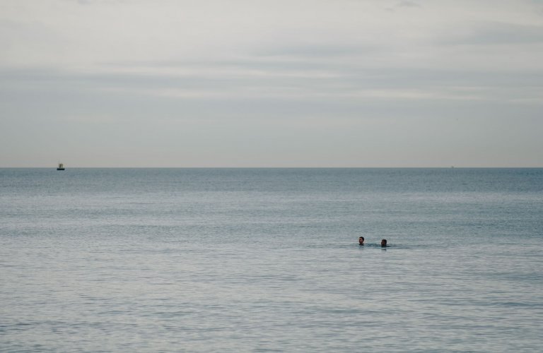 Two people swimming in Vouliagmeni in winter