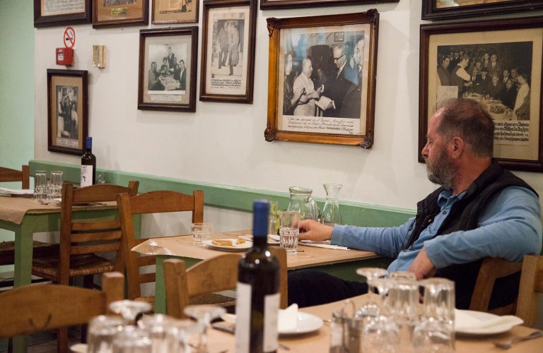 A man sitting at a taverna table 