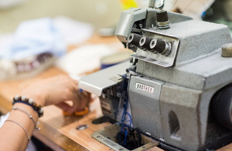 a woman's hand next to a sewing machine