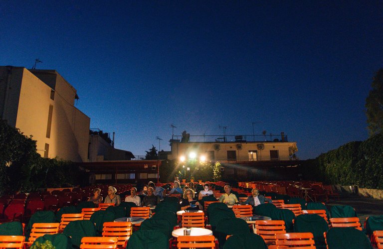 orange chairs, green tables in city movie theatre