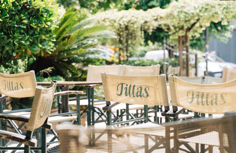 tables and chairs in a yard with plants