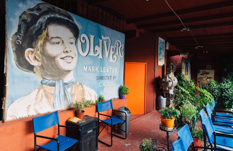 a poster of the film Oliver twist at the back of rows of open-air cinema chairs