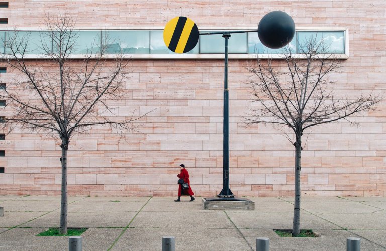 A person walking outside the Benaki Museum Pireos Annexe in Athens.