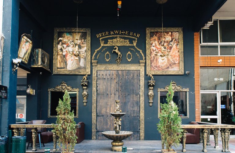 A wooden door and tables of a wine and beer bar in Piraeus. 