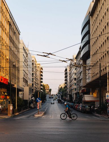 A man riding a bicycle in the street of Piraeus. 