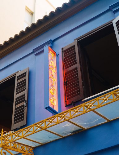 a tattoo neon sign at Popeye Loves Olive in Athens