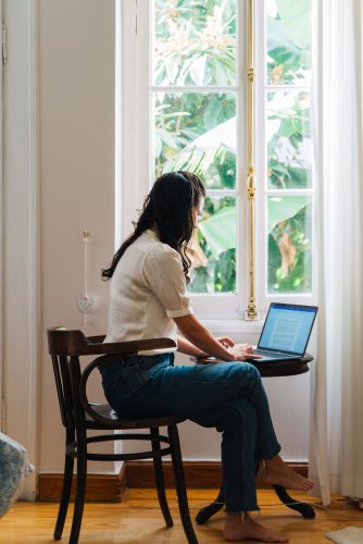 a woman sitting at her desk in her home in Athens