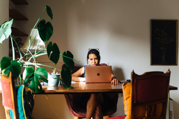 a woman sitting on her desk working on her laptop in Athens