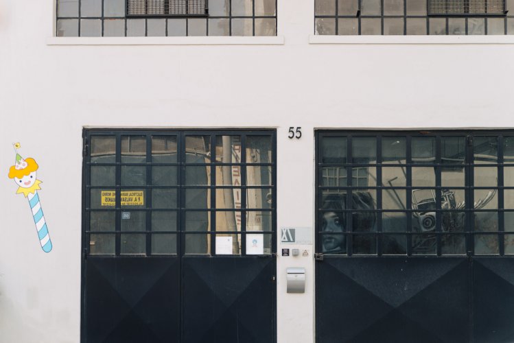 A building entrance with two heavy iron sliding doors with windows