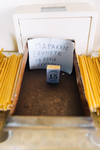 a handwritten note inside a chapel at the candle charity box in Mount Pendeli in Athens