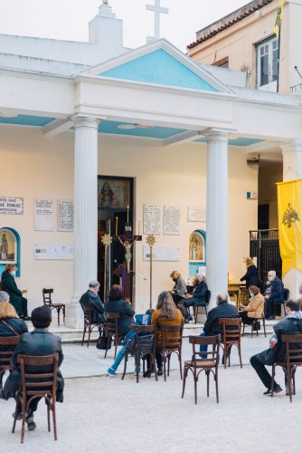 people sitting in chairs outside of an Orthodox church