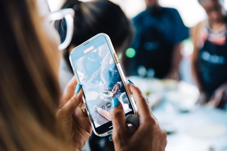 a shot of a mobile phone that's photograping a group of people in a cooking class