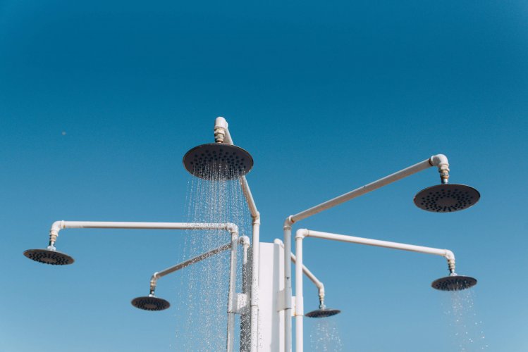 showerheads at the beach, crystal clear blue sky.