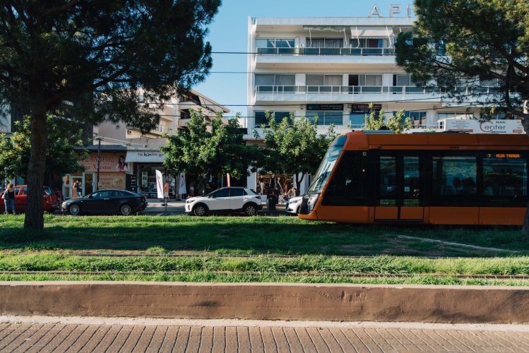 an orange tram on the move, urban backround.