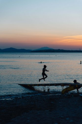 two boys playing at the sea after sunset.