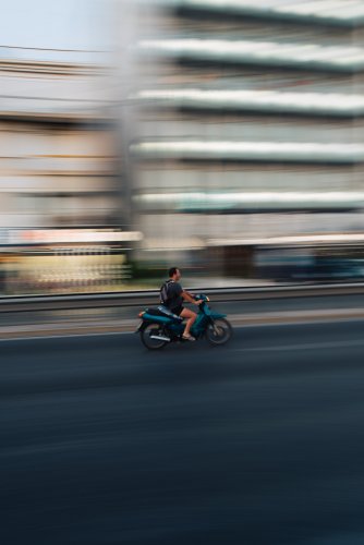 a man on a motorcycle wearing flip flops.