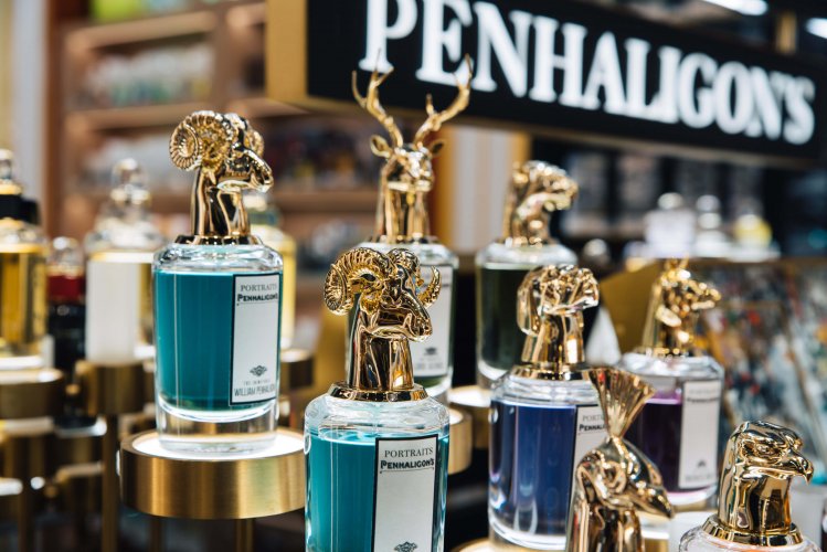 Perfume bottles with gold details on top, a sign at the background writing "penhaligon's".