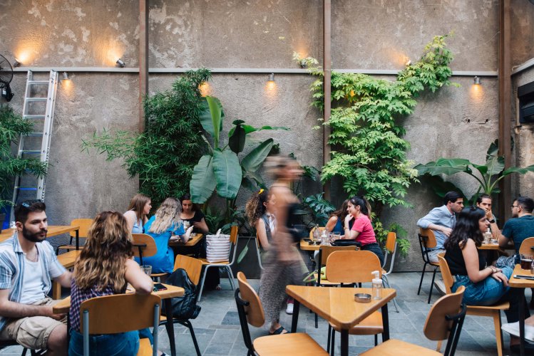 people having coffee at the backyard of a coffee shop.