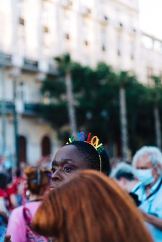 a  black woman marching wearing a "love is love" headband.