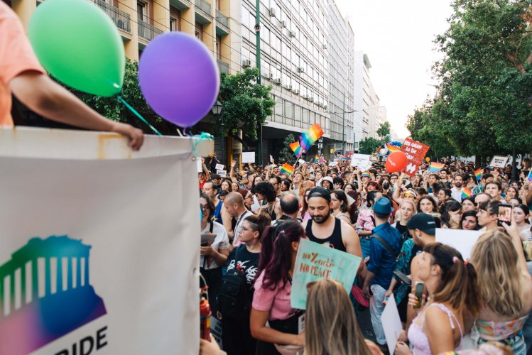 Marchers at the Athens Pride parade, balloons and signs.