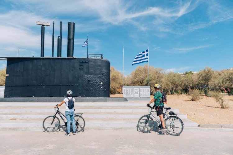 a woman and a man on their bikes looking at the Submarine Monument.