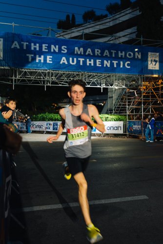 a runner approaching the finishing line after dusk.