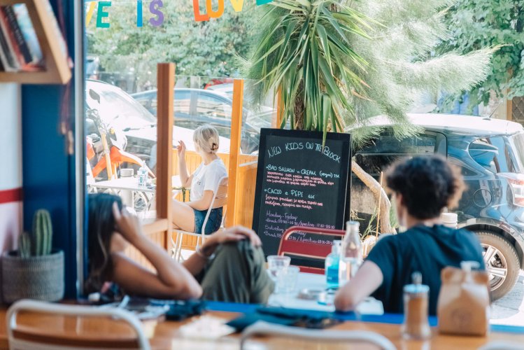 people sitting at a cafe outdoors, sunny day.