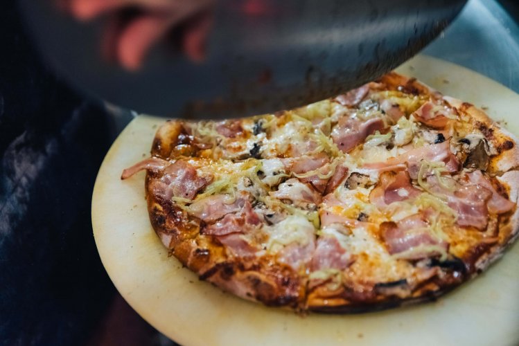 a pizza on a wooden tray.