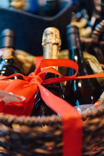 a basket with wines wrapped with a red ribbon. 