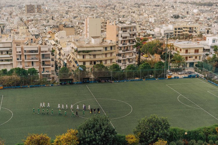 two football teams ready to start a game, blocks of flats at the background. 