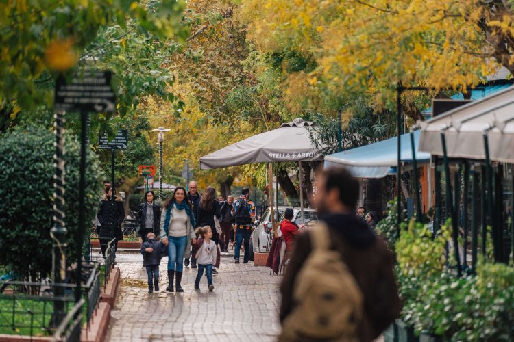 people walking at a pedestrian street, coffee shops around. 