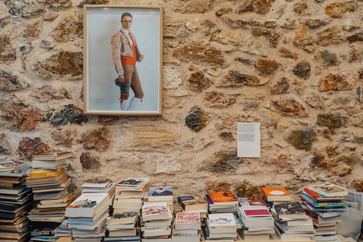 piles of books against a wall.