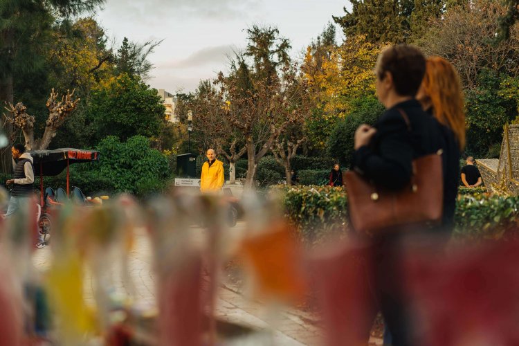 people walking at the park, colourful lollipops in front of the camera.