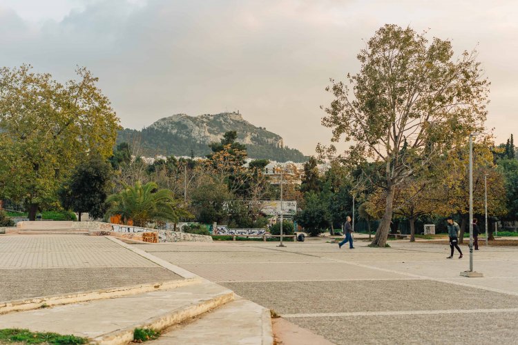 cloudy skies, autumn colours and leaves on trees, shot of a square, a mountain at the backround