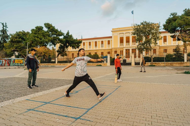 kids playing at a square, a big yellow building at the background. 