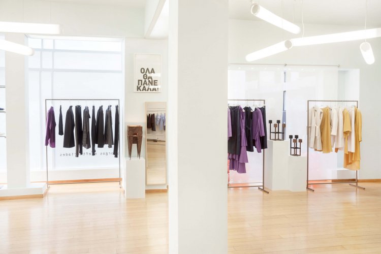 a view of the Yiorgos Eleftheriades' boutique interior, clothes hanging, white walls.