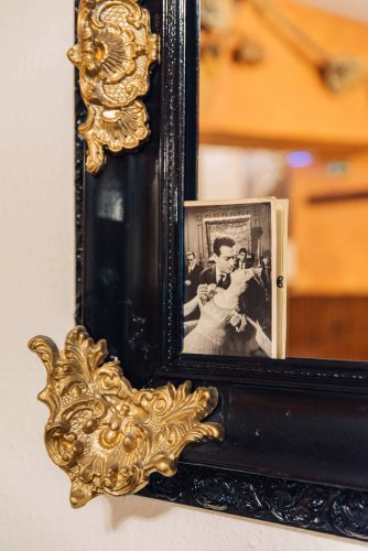 a black and white photo of a man and a woman dancing set on the corner of a mirror. 