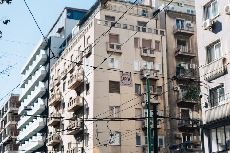 blocks of flats, a road sign that reads "slow" in Greek.