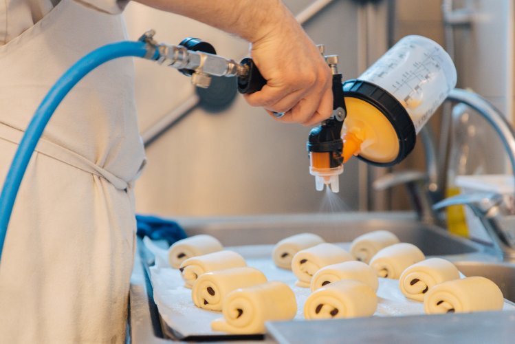 a pastry chef adding butter on croissants.