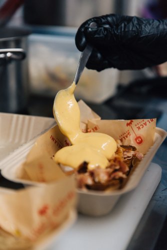 a chef adding hollandaise on eggs.