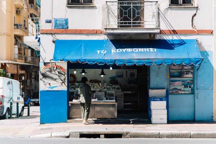 a fish shop, a woman shopping, blue tent.