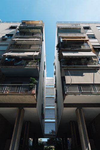 blocks of flats, blue sky between them and above.