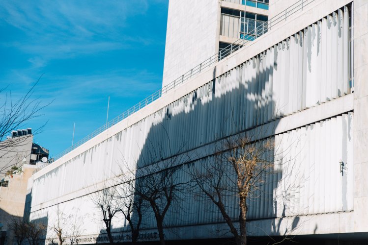 facade of a building, shadows from other buildings on it.