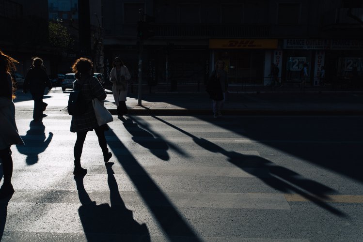 people crossing the street during sunset.